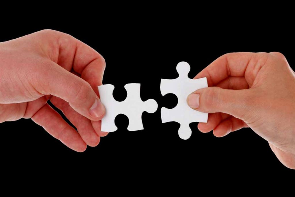 Man and woman holding a puzzle piece each